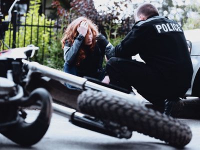 Policeman interviewing a dazed driver of a motorbike after a crash